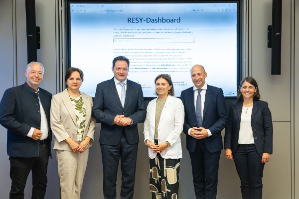 Bundesminister Totschnig mit Staatssekretärin Kraus-Winkler posieren zusammen mit jeweils zwei Vertreter:innen aus den Pilotregionen vor einem Screen auf dem das RESY-Dashboard zu sehen ist.