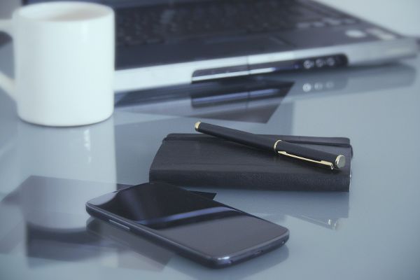 Office desk with smartphone, notebook, laptop and coffee cup