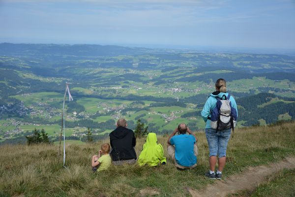 Familie mit Kindern am Hausberg mit Blick auf die untenliegendnen Ortschaften