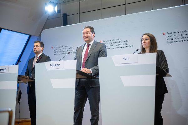 Drei Personen stehen hinter Pulten mit Namensschildern vor einer Wand mit dem Schriftzug des Bundesministeriums für Land- und Forstwirtschaft, Regionen und Wasserwirtschaft.