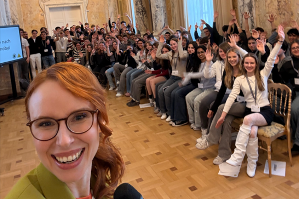 Moderatorin mit den Schüler:innen bei der Veranstaltung