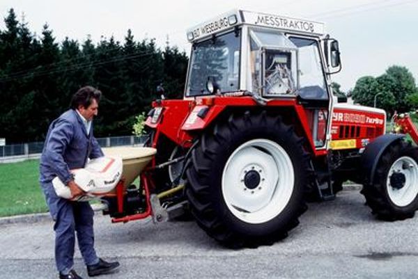 Landwirt mit seinem Traktor auf dem Weg zur Streuung