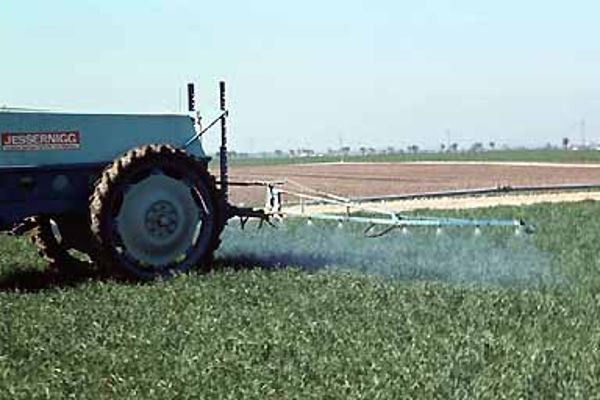 Traktor mit Anhängerbalkenspritze mit Spritzdüsenbalken