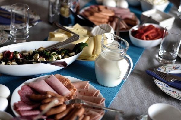 Frühstückstisch mit Eiern, Milch, Käse und Wurst