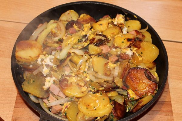 Pfanne mit Kartoffeln, Wurstresten, Zwiebeln und Ei
