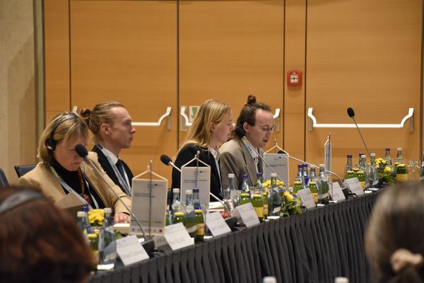 Teilnehmer der Generalversammlung geben ihr Statement am Tisch