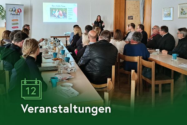 Zu sehen sind Leute, die bei einem Vortrag zu hören. 