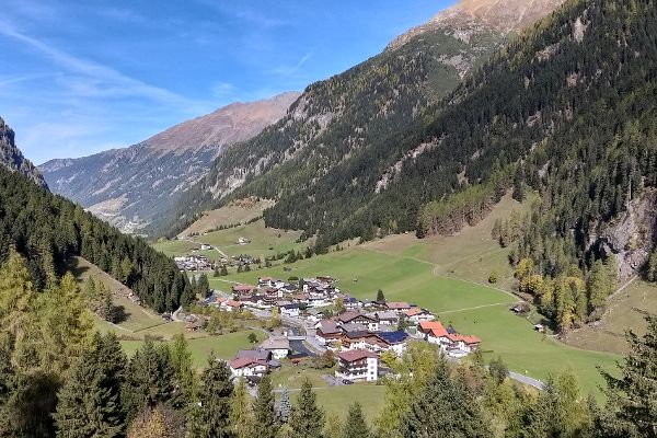 Landschaft mit einem Tal mit Siedlungen, links und rechts umgeben von steilen Bergen mit Schutzwald