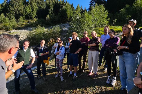Bundesminister Norbert Totschnig, Sektionsleiter Gebhard Walter und Gebietsbauleiter Josef Plank von der Wildbach- und Lawinenverbauung erklären Teilnehmer:innen der Exkursion die Verbauungsmaßnahmen am Entalbach, Tirol.