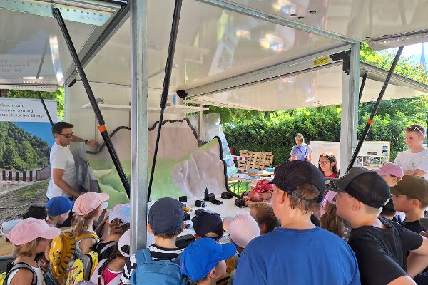 Schülerinnen und Schüler begutachten das Naturgefahrenmodell der Wildbach- und Lawinenverbauung zur Veranschaulichung von den Auswirkungen von Naturgefahren 
