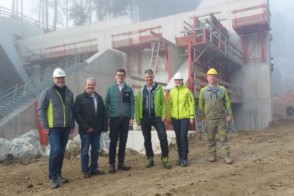 Gruppenfoto von Gebietsbauleiter Anton Pichler, Bürgermeister von Köstendorf Wolfgang Wagner, Landesrat Maximilian Aigner, Sektionsleiter Wildbach- und Lawinenverbauung Gebhard Neumayr und zwei Mitarbeiter:innen der Wildbach- und Lawinenverbauung Viktoria Sandtner und Martin Lanner