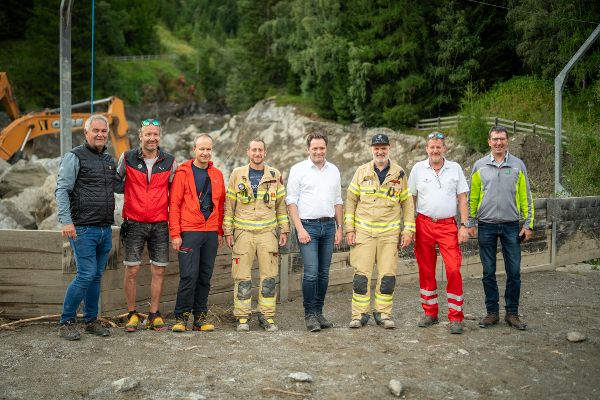 Gruppenfoto vom Lokalaugenschein in St. Anton mit Bundesminister Totschnig und Einsatzkräften