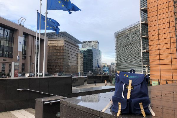 Rucksack stehend auf einer Hausmauer im Hintergrund Flaggen