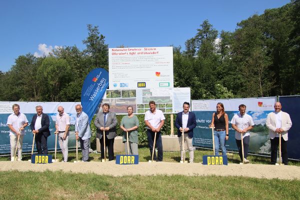 Zusehen ist die Spatenstichfeier für die Renaturierung der Strem in Ollersdorf – Litzelsdorf. Auf den Bild zu sehen ist, von links: Christian Sailer (Landeswasserbau), Wolfgang Wukovits (Wasserbauamt), Bürgermeister Bernd Strobl (Ollersdorf), Sectionschefin Monika Mörth (Bundesministerium für Land- und Forstwirtschaft, Klima- und Umweltschutz, Regionen und Wasserwirtschaft), Bürgermeister Jürgen Resch (Litzelsdorf). Alle abgebildeten Personen führen gemeinsam einen symbolischen Spatenstich durch und stecken dabei den Spaten in die Erde.