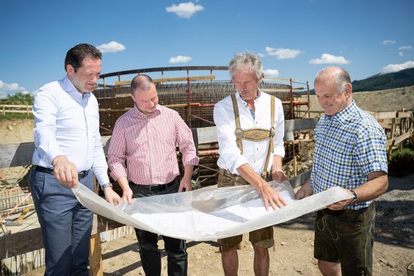 Bundesminister mit drei weiteren Personen die einen Plan lesen