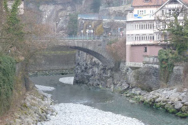 Stadthaeuser mit einer steinernen Bruecke, darunter ein Fluss