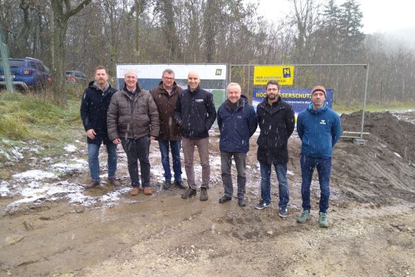 sieben Personen vor Bauzaun