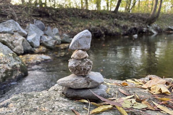 Eine Fotografie einer Steinfigur vor einem kleinen Fluss. 