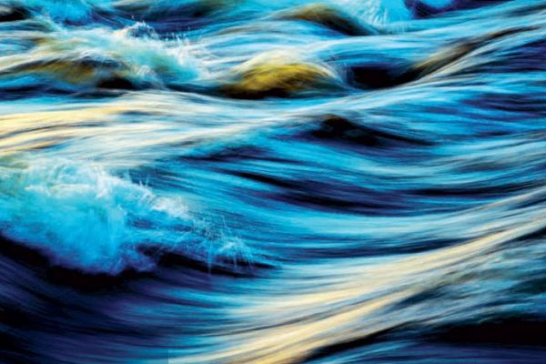 Wasserwellen in denen sich die Sonne leicht spiegelt.