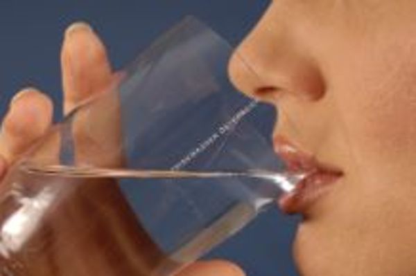 Eine Frau trinkt ein Glas Wasser.