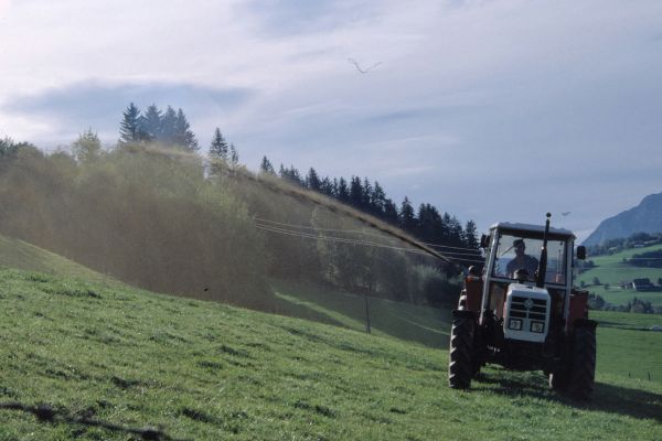 Traktor bei der Gülleausbringung am Hang
