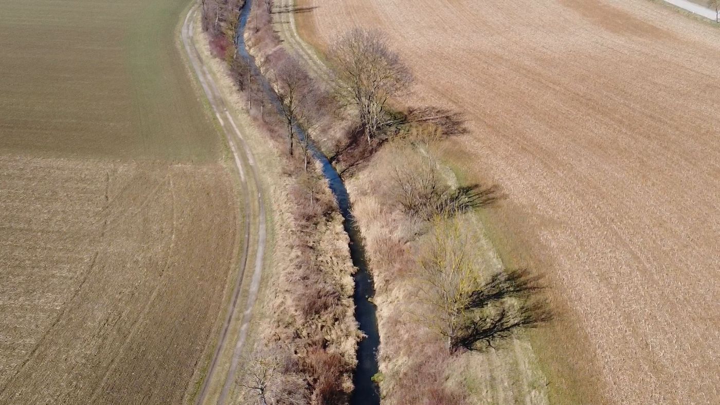 Das Bild zeigt einen kurzen Teilabschnitt des Verlaufes vom Göllersbach von oben, links und rechts sind Felder sichtbar
