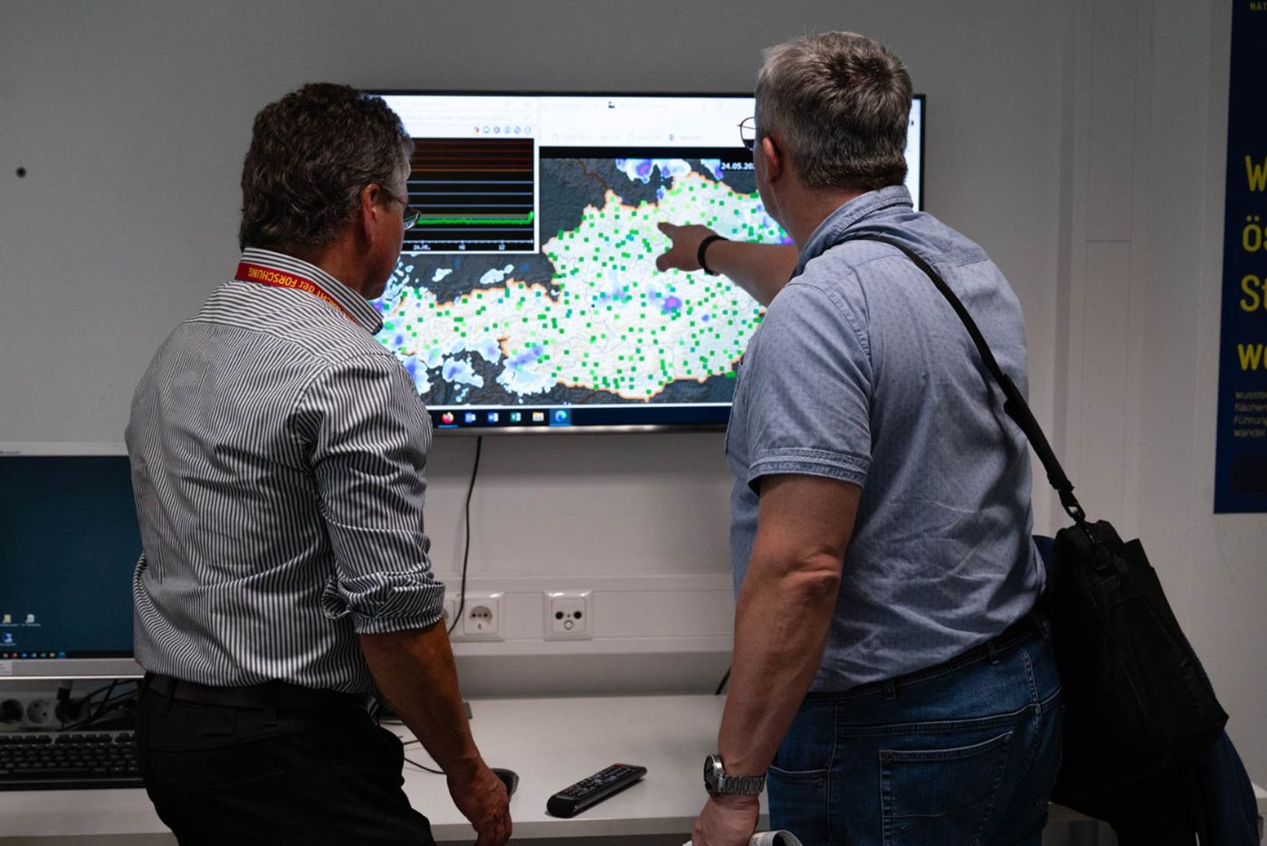Abteilung Strahlenschutz - Besucher stehen vor einer digitalen Karte Österreichs mit Netz aus Messstationen