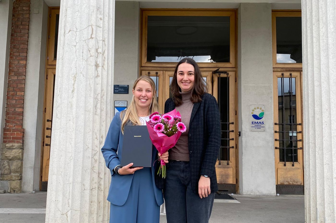 Anna Jansel und Verena Matlschweiger mit einem Blumenstrauß auf einer Treppe