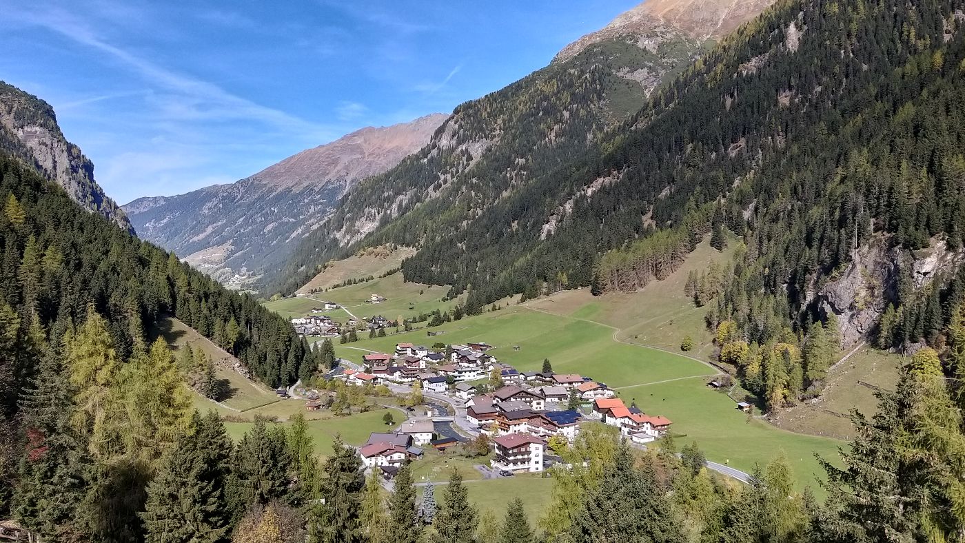 Landschaft mit einem Tal mit Siedlungen, links und rechts umgeben von steilen Bergen mit Schutzwald