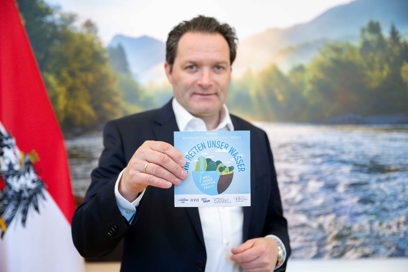 Bundesminister Norbert Totschnig hält den Trinkpass in der Hand.
