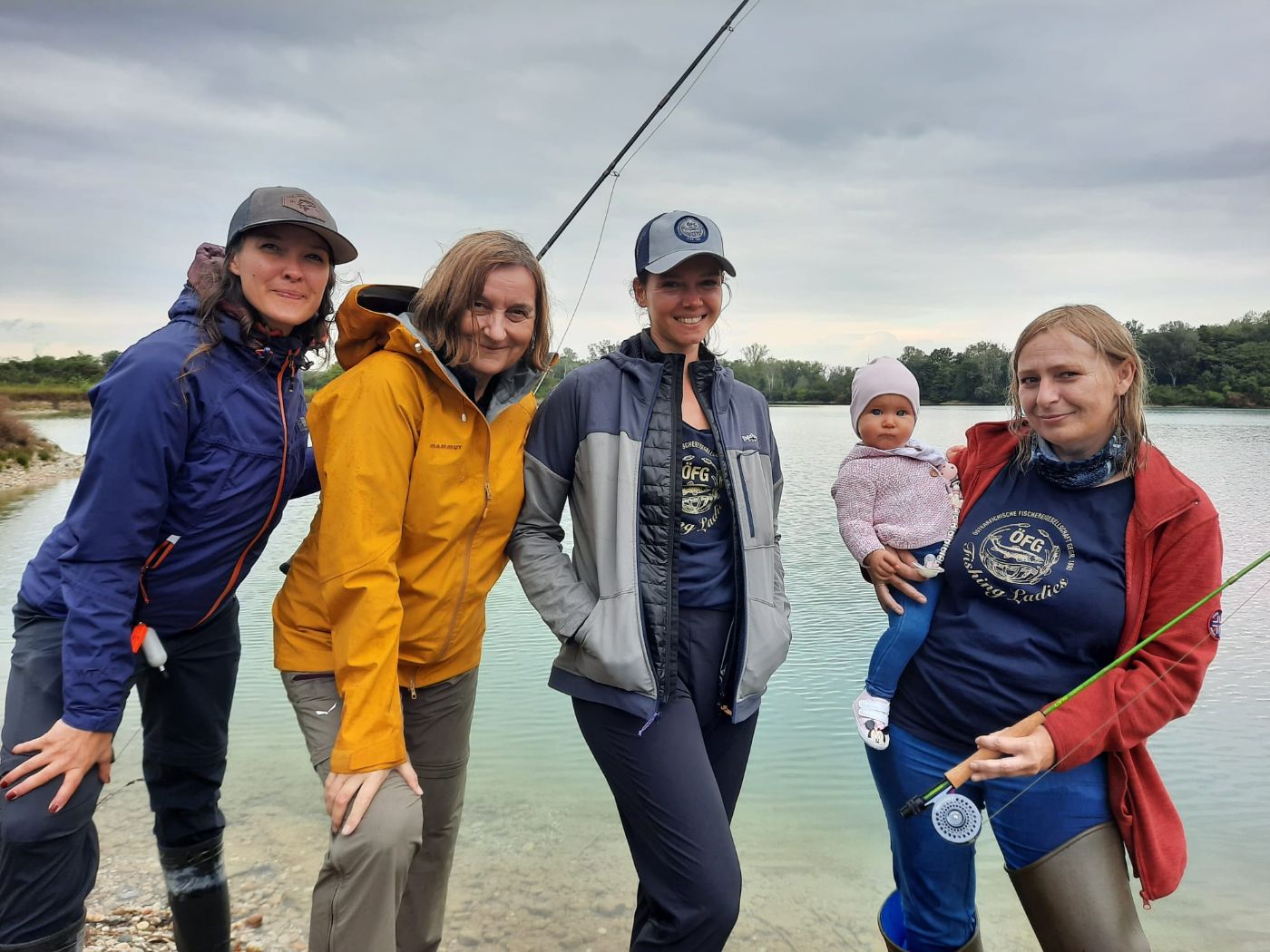 Gruppe von Frauen mit Angelrute und Baby am Arm