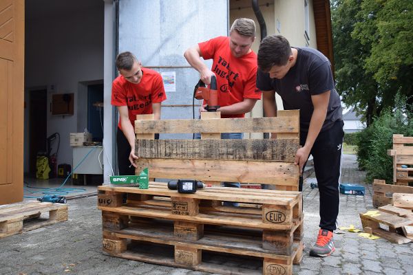 Mehrere Personen arbeiten mit Holz