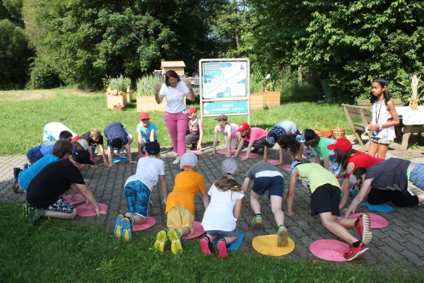 Kinder machen Bodenübungen nach Anweisung einer Betreuerin