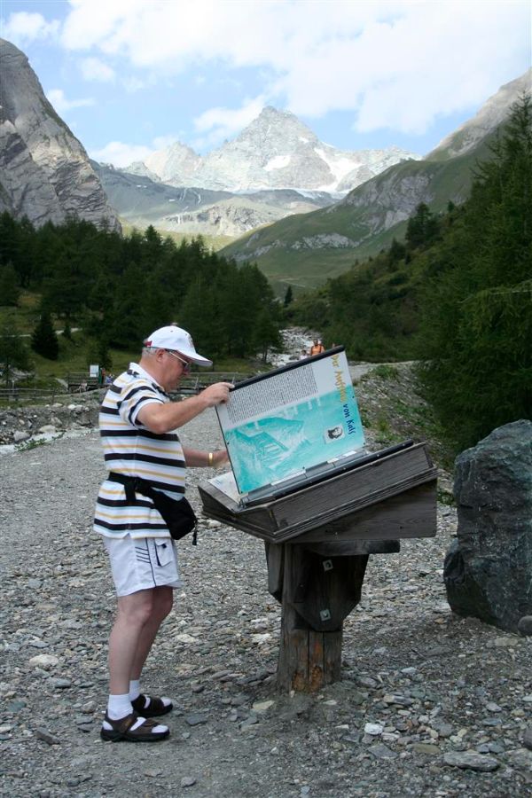 Wanderer steht an einer Informationstafel