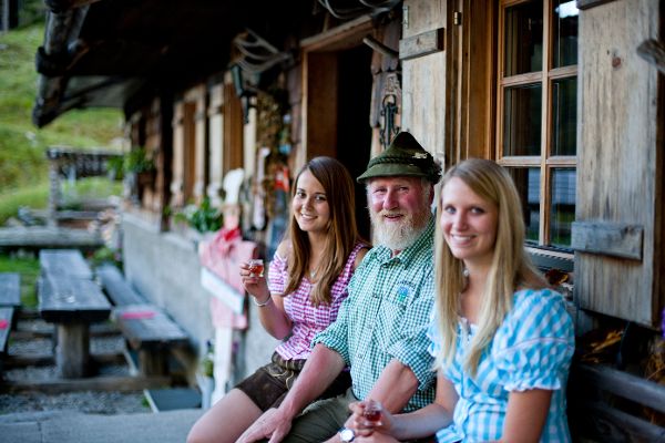 Zwei Wanderinnen auf der Hütte. Dazwischen ein graubärtiger, alter Herr.