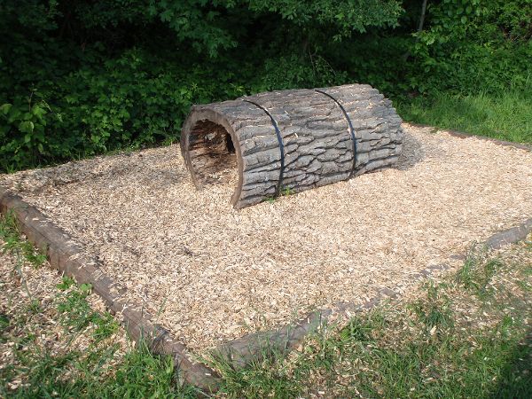 Ein ausgehöhlter Baumstamm auf Rindenmulch