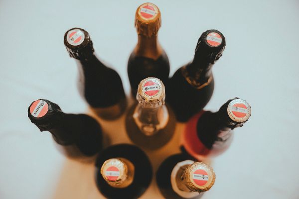 6 Sektflaschen sind von oben zu sehen, Fokus liegt auf der rot-weiß-roten Banderole. Sie signalisiert österreichischen Sekt mit geschützter Ursprungsbezeichnung.