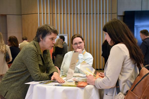 Drei Personen an einem Stehtisch