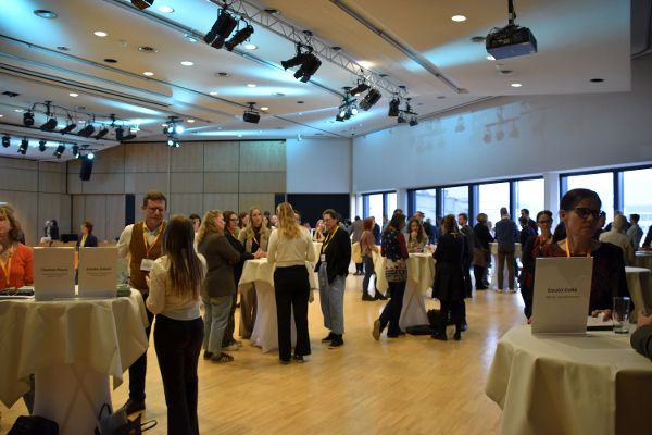 Ein Raum voller Menschen an Stehtischen