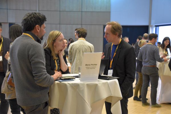 Drei Personen an einem Stehtisch