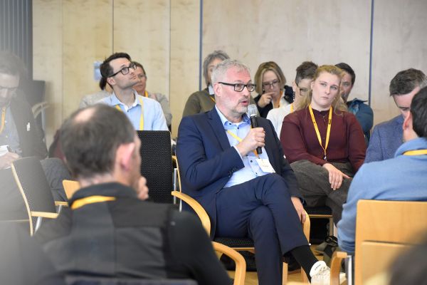 Michael Roth mit einem Mikrofon in der Hand