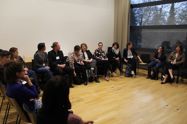 Menschen auf Sesseln in einem Kreis sprechen miteinander