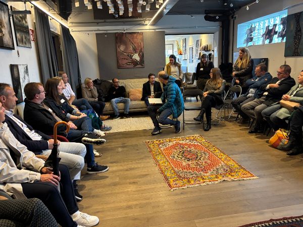 Zu sehen sind die Teilnehmende sitzend in der Homebase, im Kreis