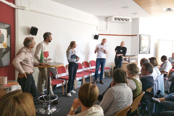 Fünf Experten und Expertinnen unterhalten sich am Podium. Die Teilnehmenden hören zu.