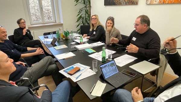 Workshop Teilnehmende in einer Runde am Tisch