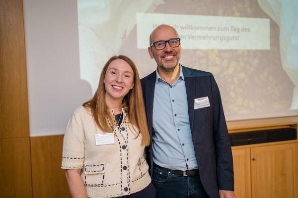 Stephanie Salzmann und Silvio Schüler stehen vor der Präsentation "Tag des forstlichen Vermehrungsgutes" und lächeln in die Kamera.
