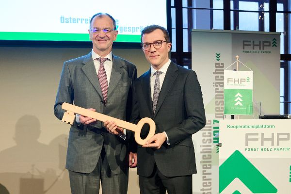 Erich Wiesner und Konrad Mylius halten gemeinsam einen überdimensionalen Schlüssel aus Holz