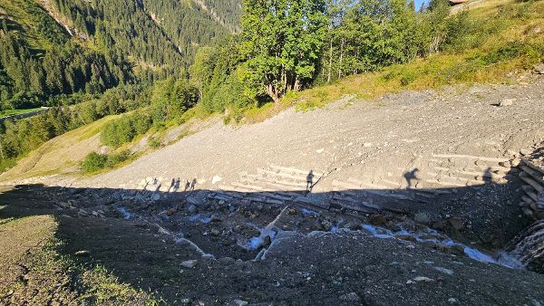 Aufstieg der Teilnehmer:innen der Exkursion zu einer aktiven Baustelle der Wildbach- und Lawinenverbauung entlang von Verbauungsmaßnahmen am Entalbach, Tirol. 