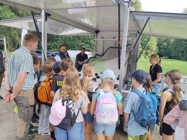 Schülerinnen und Schüler der Volksschule Straß im Attergau begutachten das Naturgefahrenmodell der Wildbach- und Lawinenverbauung zur Veranschaulichung von den Auswirkungen von Naturgefahren 