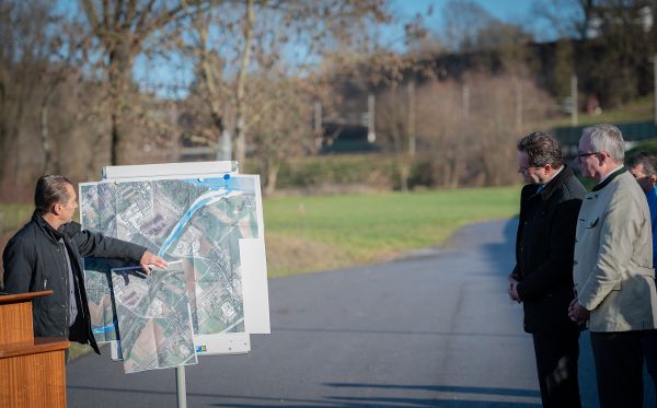 Ein Herr erklaert auf einer Karte  anderen Personen den Verlauf an der Ybbs